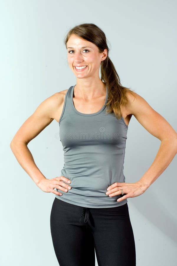 Woman in white tank top and gray leggings sitting on concrete