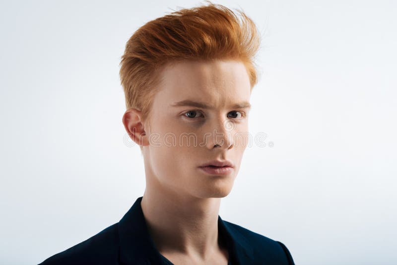 Determined red-headed young man staring