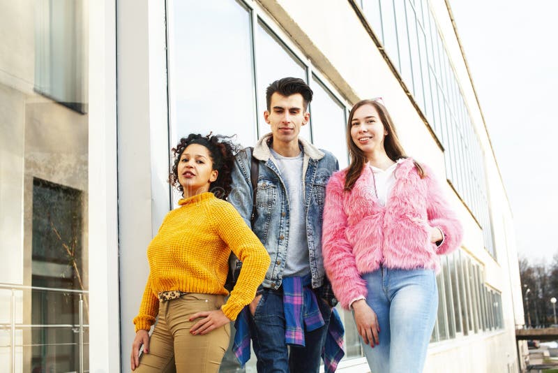 Cute group of teenages at the building of university with books huggings, diversity nations real students lifestyle stock photography Cute group of teenages at the building of university with books huggings, diversity nations real students lifestyle stock photography