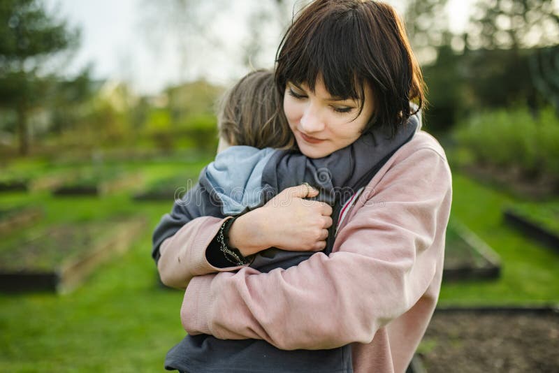 Cute große Schwester kuschelt mit ihrem kleinen Bruder. Adorable Teenagermädchen umarmt ihr kleines Geschwister. Kinder, die die N lizenzfreie stockfotos