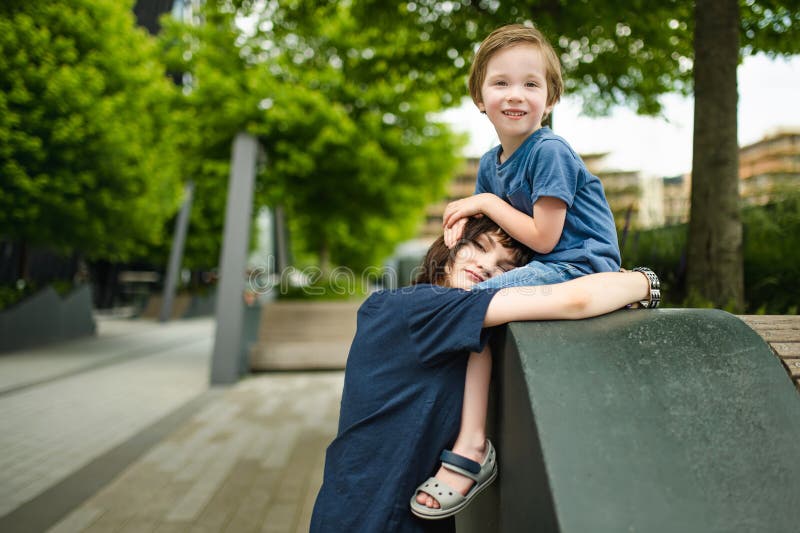 Cute große Schwester kuschelt mit ihrem kleinen Bruder. Adorable Teenagermädchen umarmt ihr kleines Geschwister. Kinder, die die N stockfoto