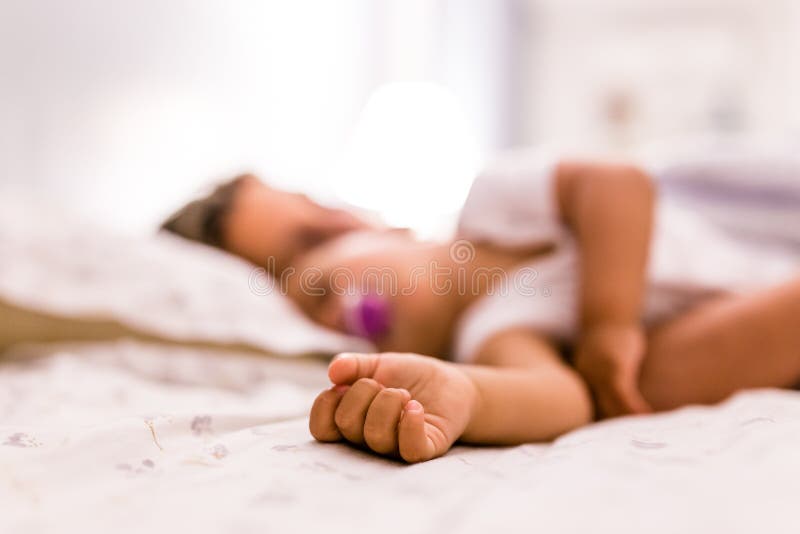 Cute hand of baby girl sleeping with her mother, detail, blurred stock image Cute hand of baby girl sleeping with her mother, detail, blurred stock image