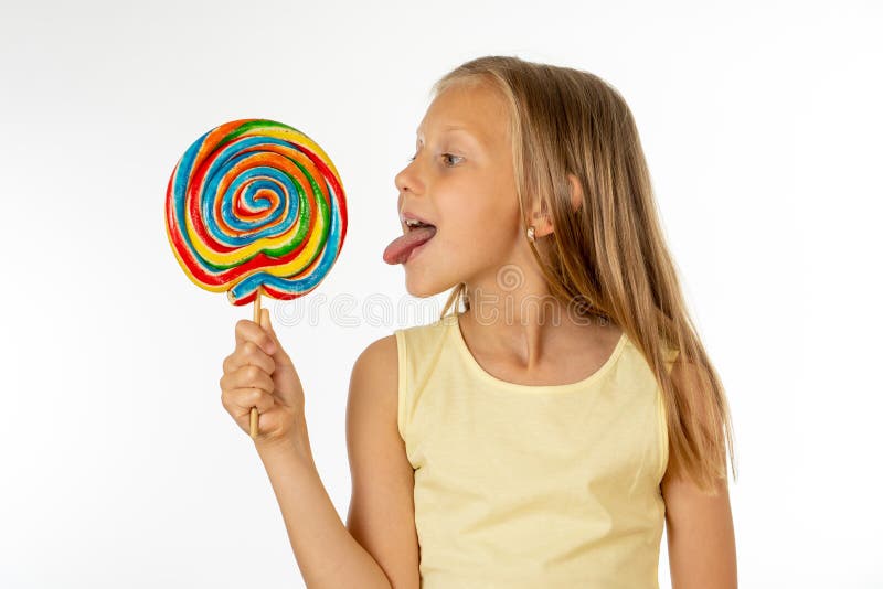 Beautiful little girl eating lollipop on white background