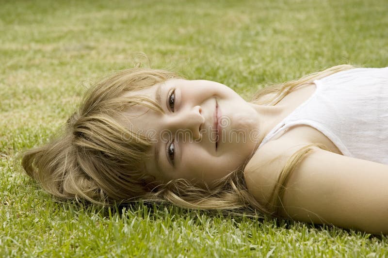 Cute happy girl smiling on grass royalty free stock photography