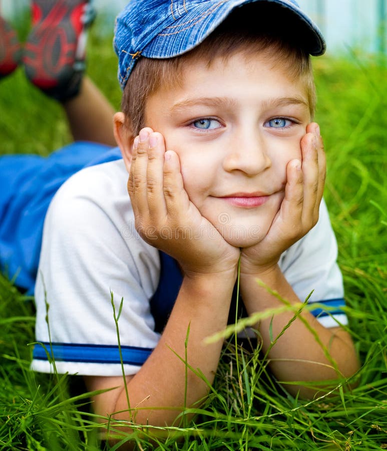 Cute happy kid laying on grass outdoor