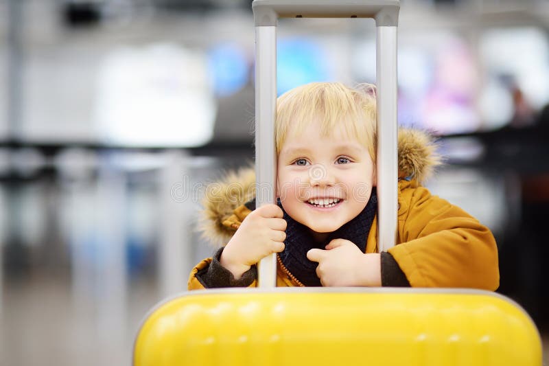 Cute happy little boy with big yellow suitcase at international airport before flight royalty free stock photos Cute happy little boy with big yellow suitcase at international airport before flight royalty free stock photos