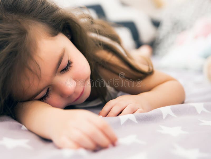 Cute happy little girl sleeping and dreaming in and bed hugging her toy. royalty free stock images Cute happy little girl sleeping and dreaming in and bed hugging her toy. royalty free stock images