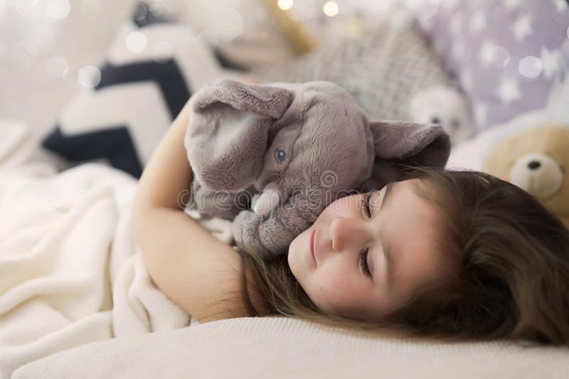 Cute happy little girl sleeping and dreaming in and bed hugging her toy. Close up photo of sleeping child stock photography Cute happy little girl sleeping and dreaming in and bed hugging her toy. Close up photo of sleeping child stock photography
