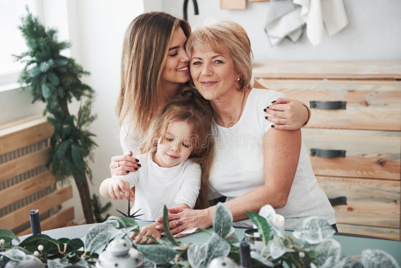 Cute hugs Moder, farmor och dotter som har god tid i köket royaltyfri foto