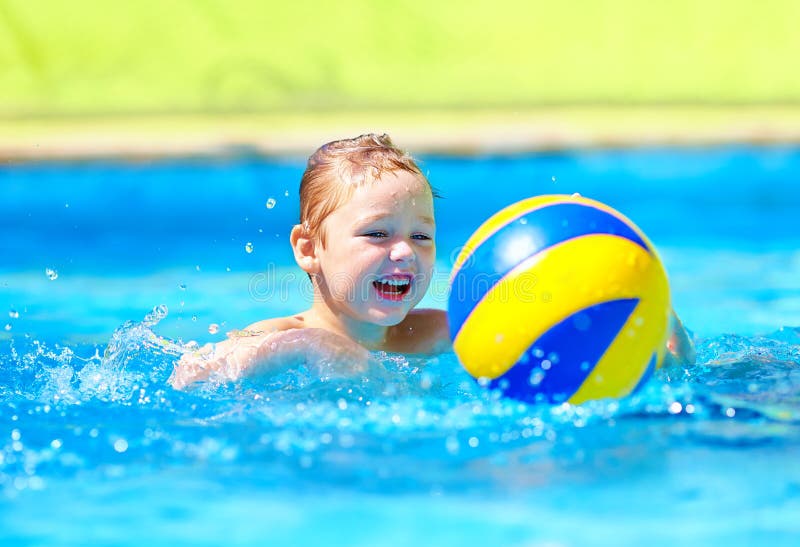 Cute kid playing in water sport games in pool