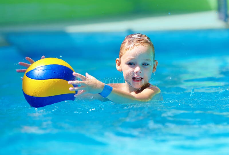 Cute kid playing water sport games in pool