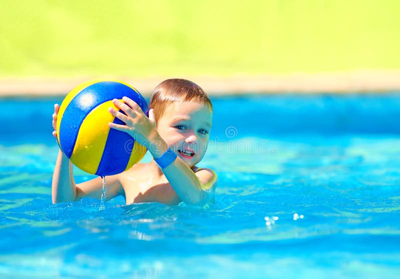 Cute kid playing in water sport games in pool