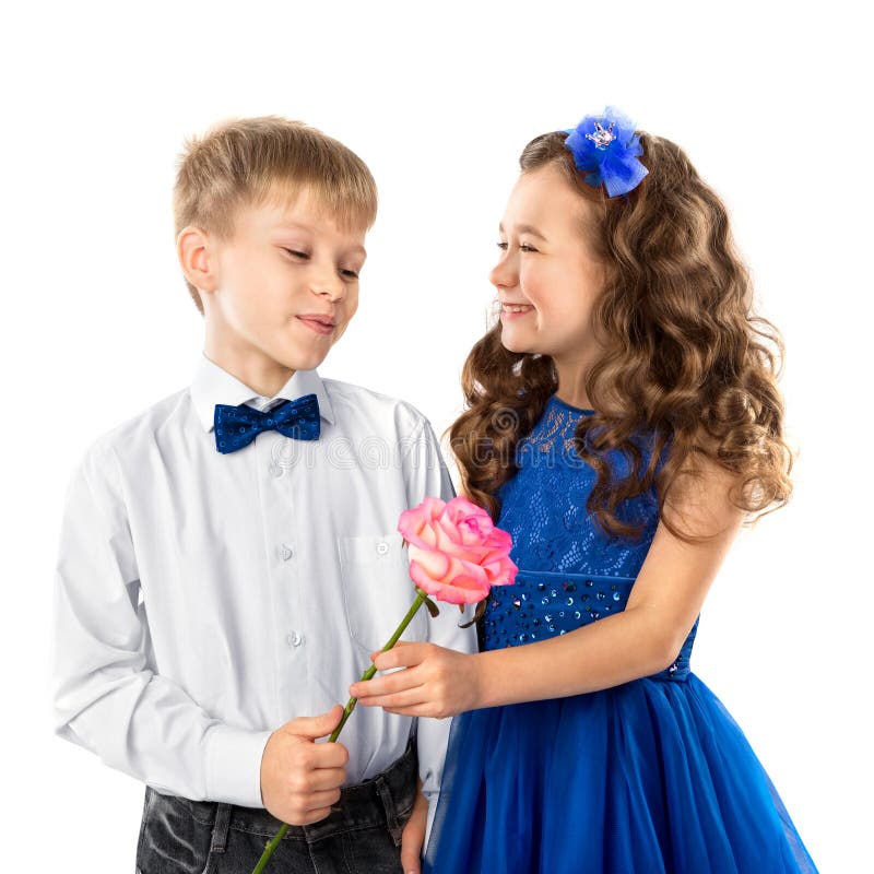 Cute kids, boy gives a flower little girl isolated on white. Valentine`s Day. Child love royalty free stock photo Cute kids, boy gives a flower little girl isolated on white. Valentine`s Day. Child love royalty free stock photo