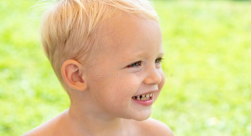 Cute kids face. Closeup portrait of smiling child boy on green background. Kid smile. Emotion concept.