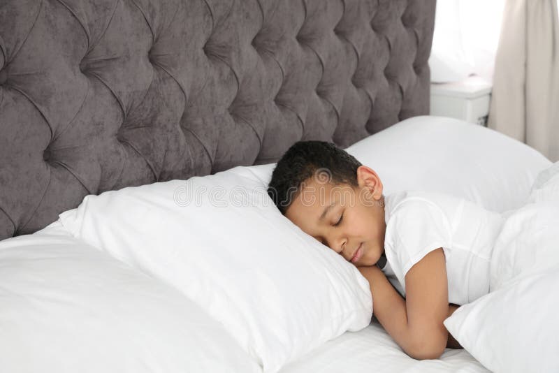 Cute little African-American boy sleeping in bed. stock photo Cute little African-American boy sleeping in bed. stock photo