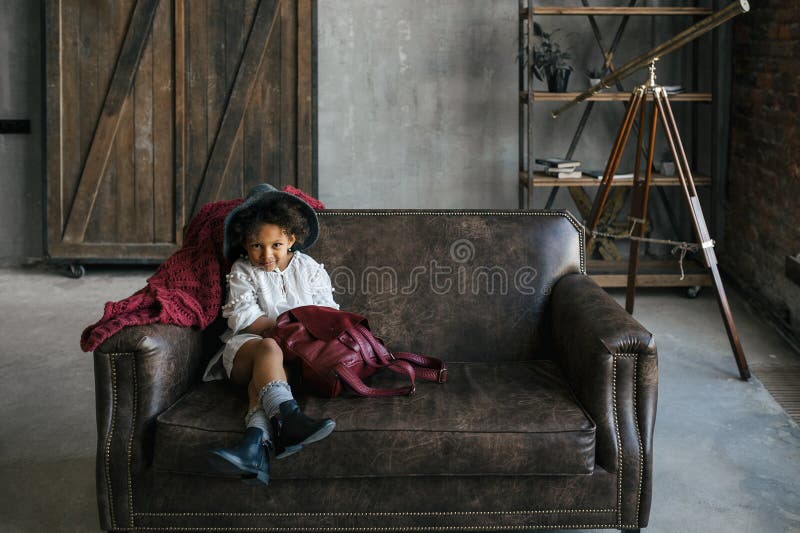 The cute little african american kid girl in a white dress and a gray hat stock photos