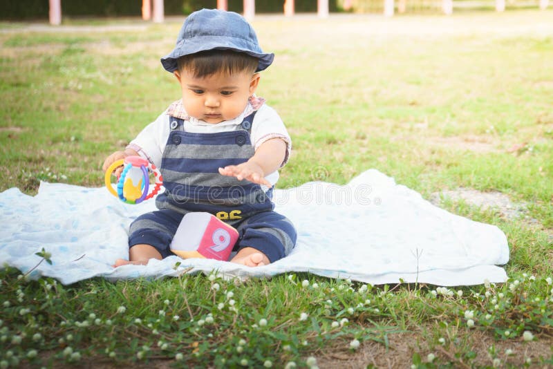 Cute little asian baby sitting in garden,vintage tone