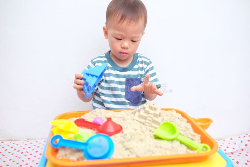 Asian 18 months / 1 year old toddler boy playing with kinetic sand at home ,Fine motor skills development, Montessori education