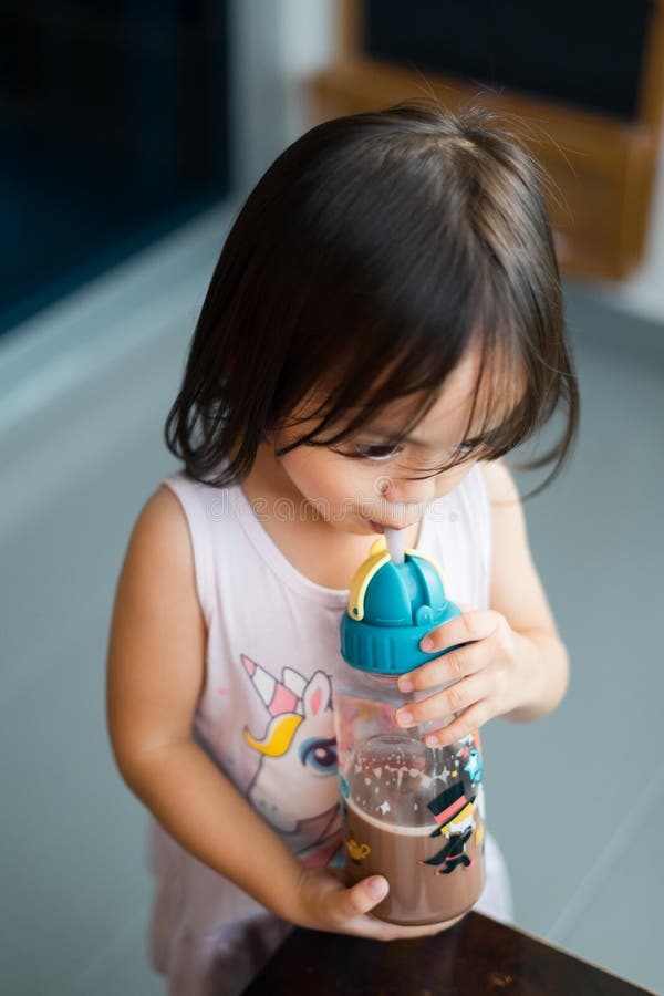 Toddler girl drinking water from the baby bottle Stock Photo