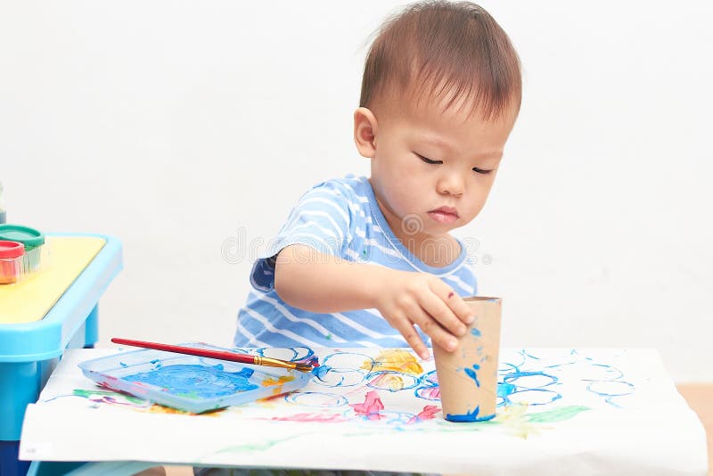 Cute little Asian 1 year old toddler boy child painting with toilet paper roll at home, Art for kid