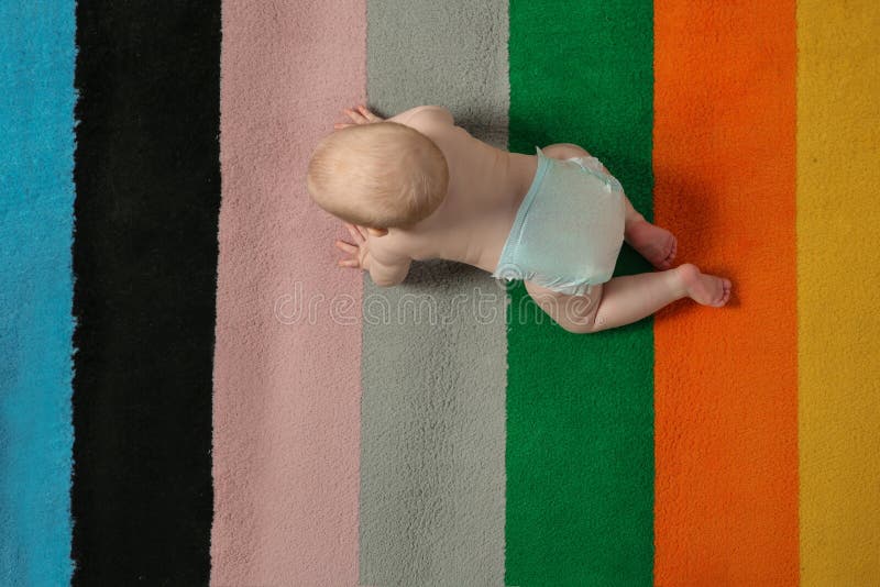 Cute little baby crawling on colorful carpet indoors, stock photos Cute little baby crawling on colorful carpet indoors, stock photos