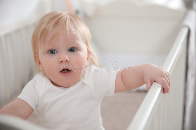 Cute little baby in crib stock image. Image of girl 187966079