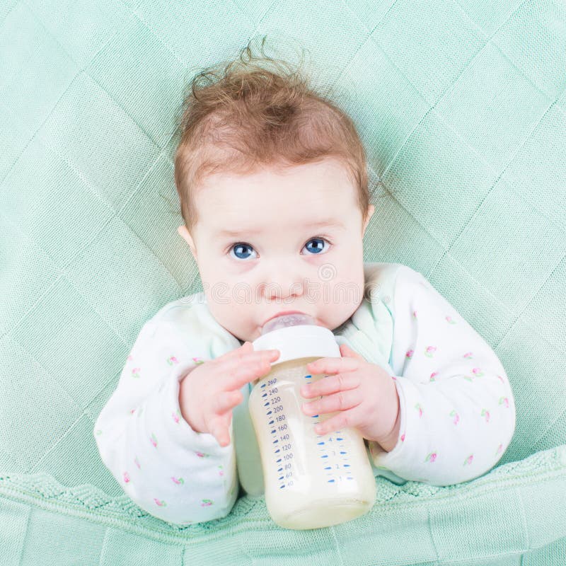Cute little baby drinking milk formula out of bottle stock image Cute little baby drinking milk formula out of bottle stock image