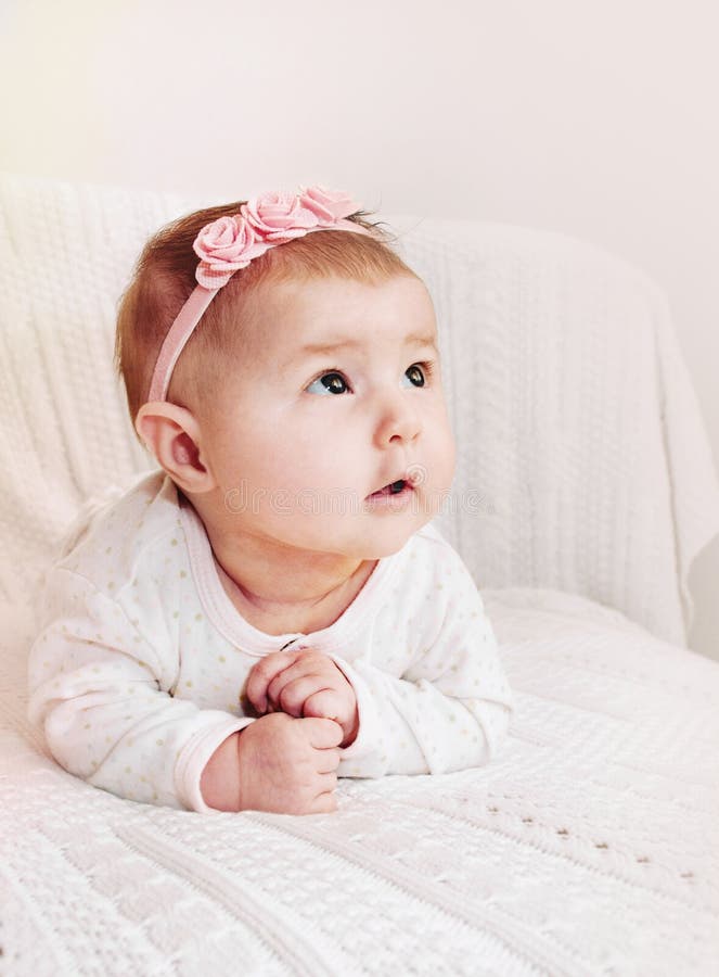 Cute little baby girl with pink headband exploring the world