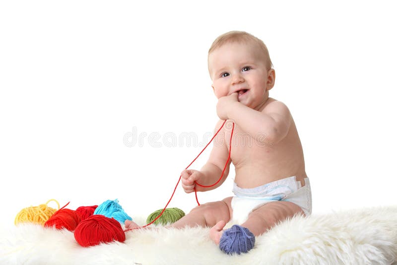 Cute little baby playing with balls of wool