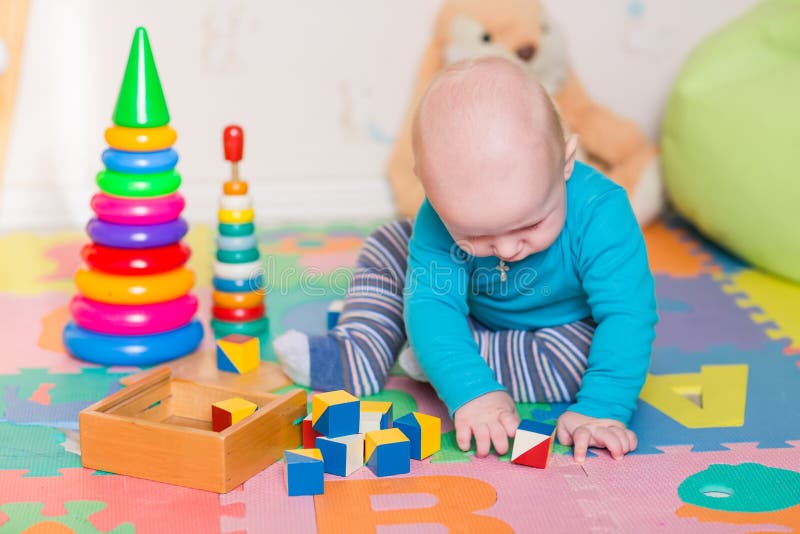 Cute little baby playing with colorful toys