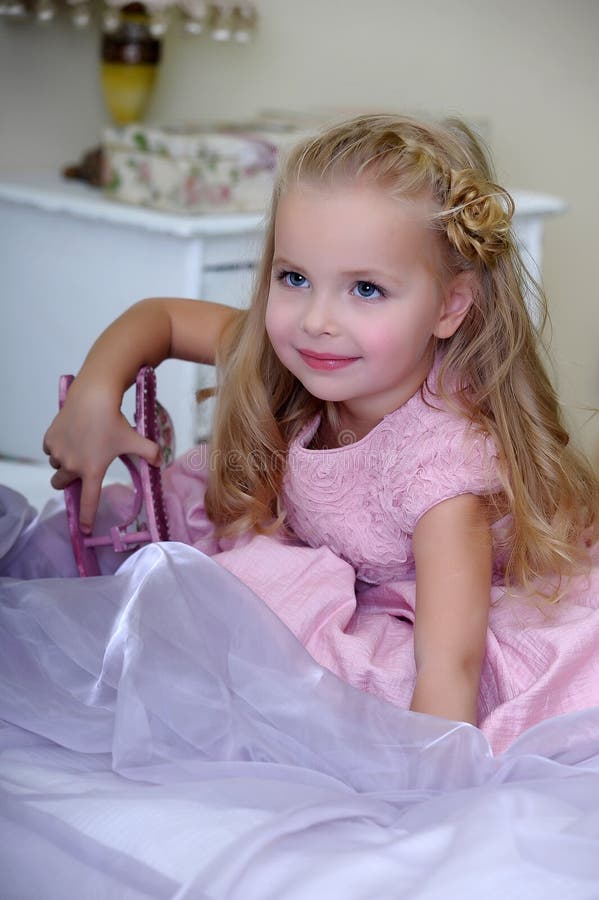 Little Blonde Girl In A Pink Dress With Curls And A Beautiful Hairstyle Stock Image Image Of 