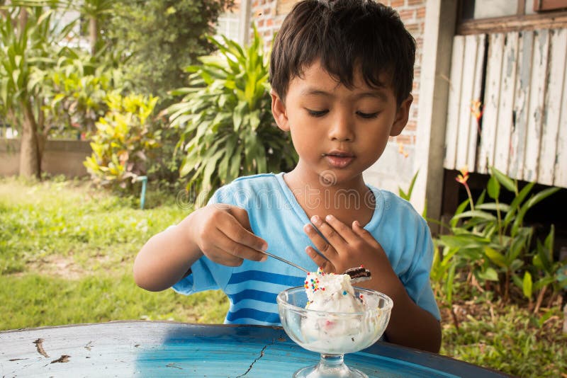 Cute little boy eating ice cream stock photography