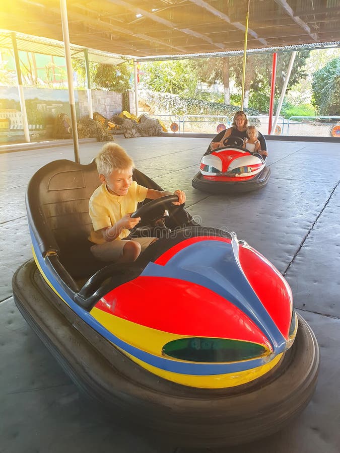 Cute little boy with mother and sister having fun in electric bumper car in amusement park royalty free stock image Cute little boy with mother and sister having fun in electric bumper car in amusement park royalty free stock image