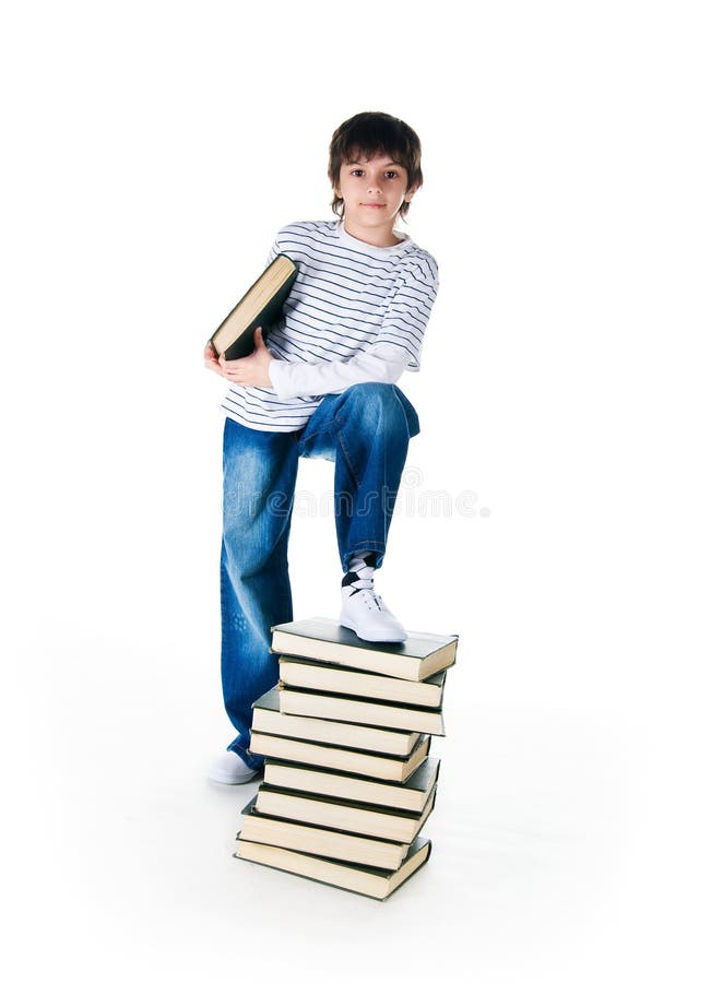 Cute little boy near the stack of big books