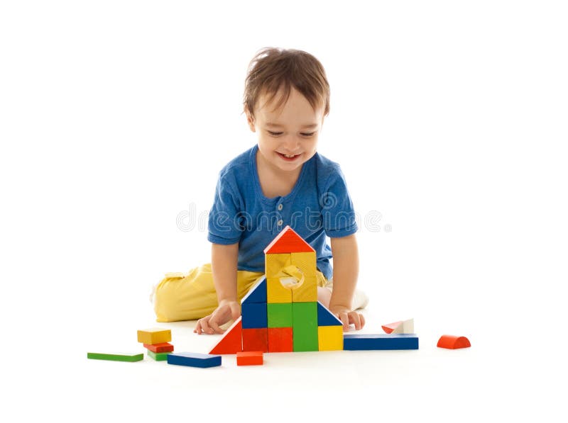 Cute little boy is playing with colorful building stock photos