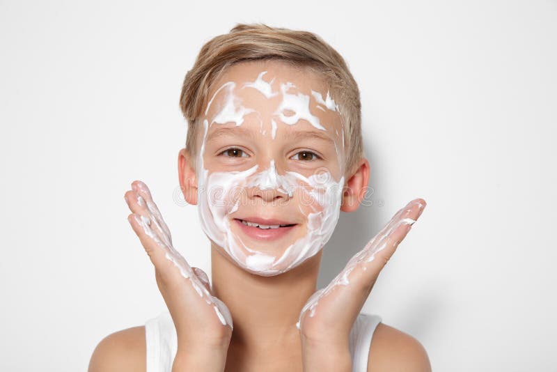 Cute little boy with soap foam on face royalty free stock photos