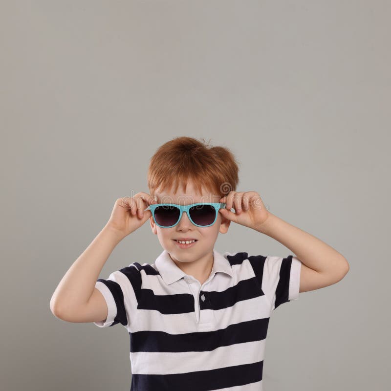 Cute Little Boy with Sunglasses on Light Blue Background Stock Photo