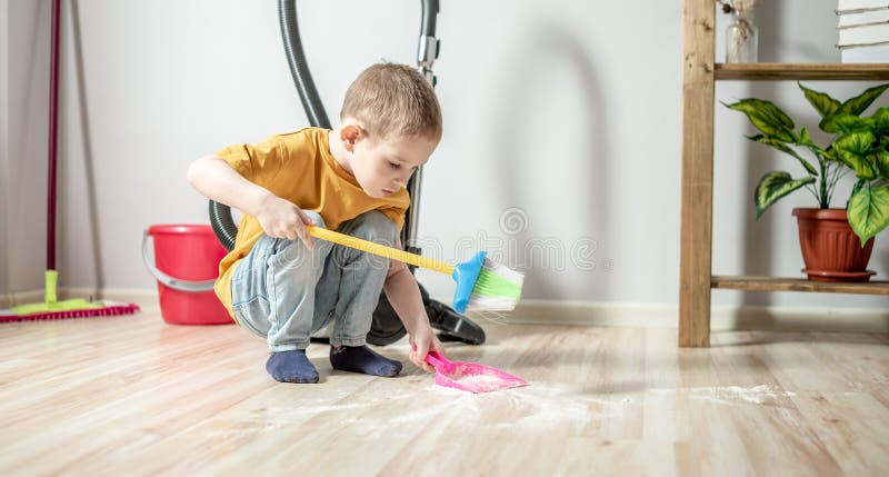 Little Boy is Sweeping the Trash from the Floor with a Broom To a Dustpan.  Child Helps the Parents in Cleaning the House Stock Photo - Image of clear,  home: 217857862