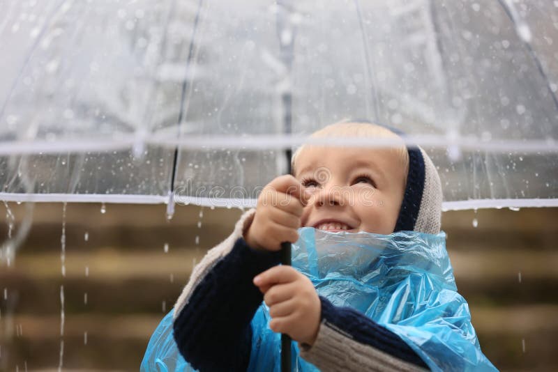 Cute Little Boy with Transparent Umbrella Under Rain Outdoors Stock