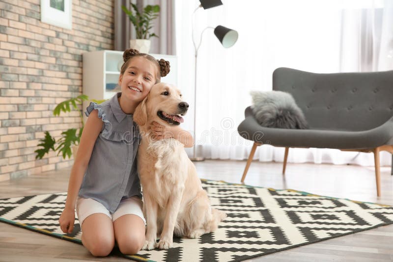 Cute little child with her pet on floor at home