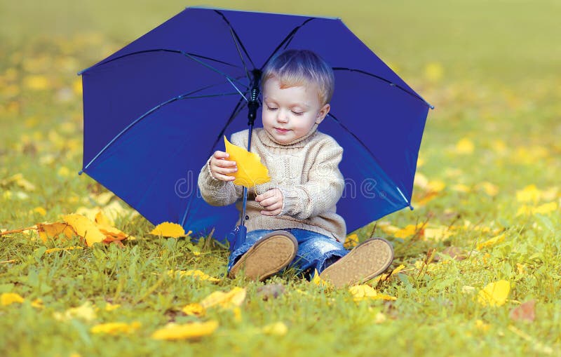 Cute little child with umbrella in autumn