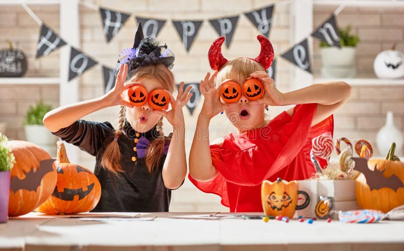 Cute little children girls with carving pumpkin. Happy family preparing for Halloween. Funny kids at home. Cute little children girls with carving pumpkin. Happy family preparing for Halloween. Funny kids at home.