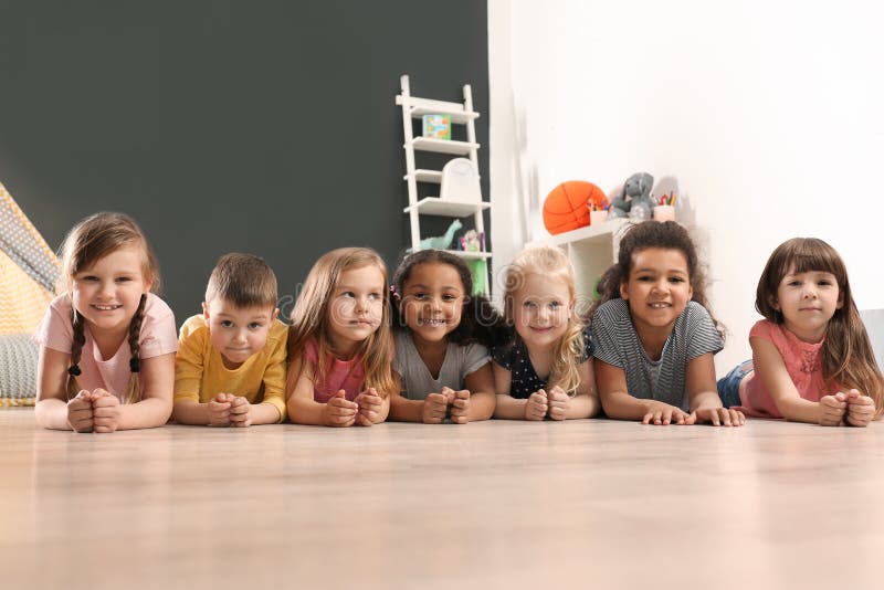 Cute little children lying on floor in kindergarten stock image Cute little children lying on floor in kindergarten stock image