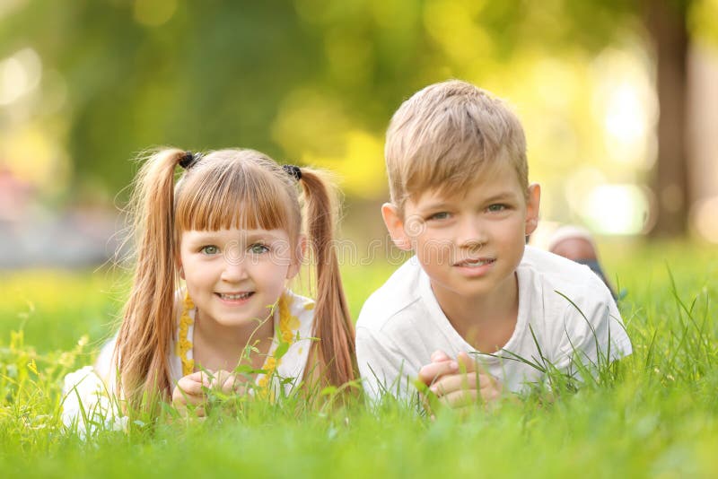 Cute Little Children Lying on Green Grass Outdoors Stock Image - Image ...