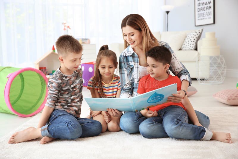 Cute little children reading book on floor stock photo Cute little children reading book on floor stock photo