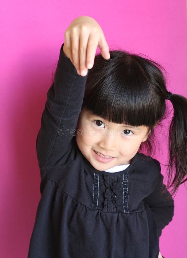 cute little chinese asian girl with arm in air