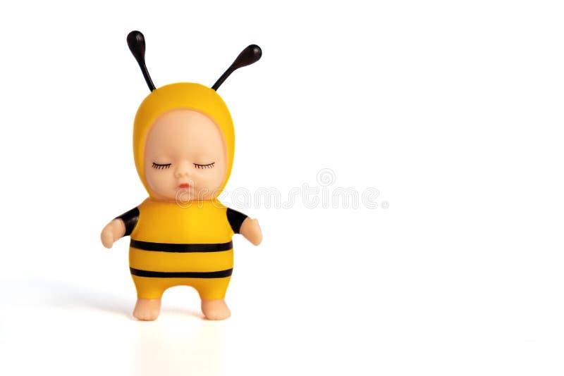 Cute little doll in a bee costume with closed eyes. Stands on a white Cisolated background. Soft focus. Copy space.