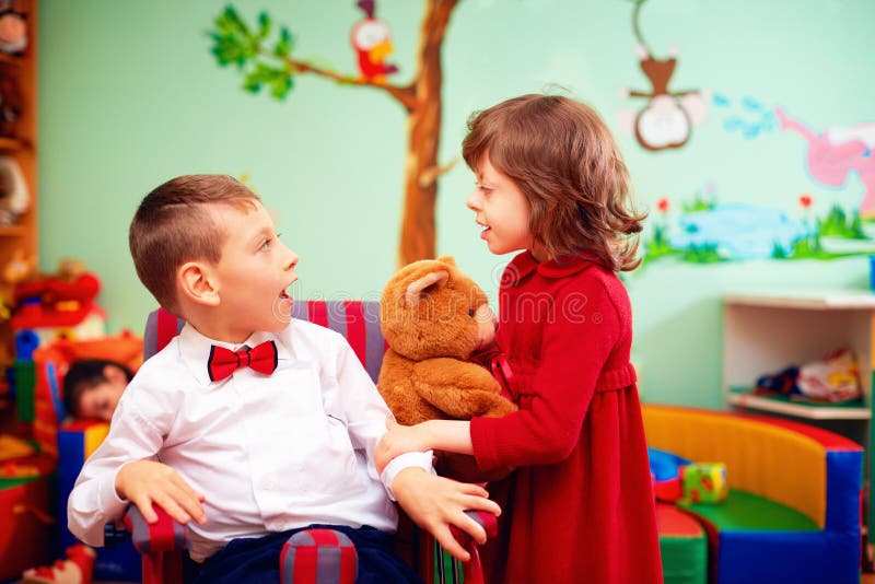 Cute little gentleman in wheelchair and lady on holidays in kindergarten for kids with special needs royalty free stock photography Cute little gentleman in wheelchair and lady on holidays in kindergarten for kids with special needs royalty free stock photography