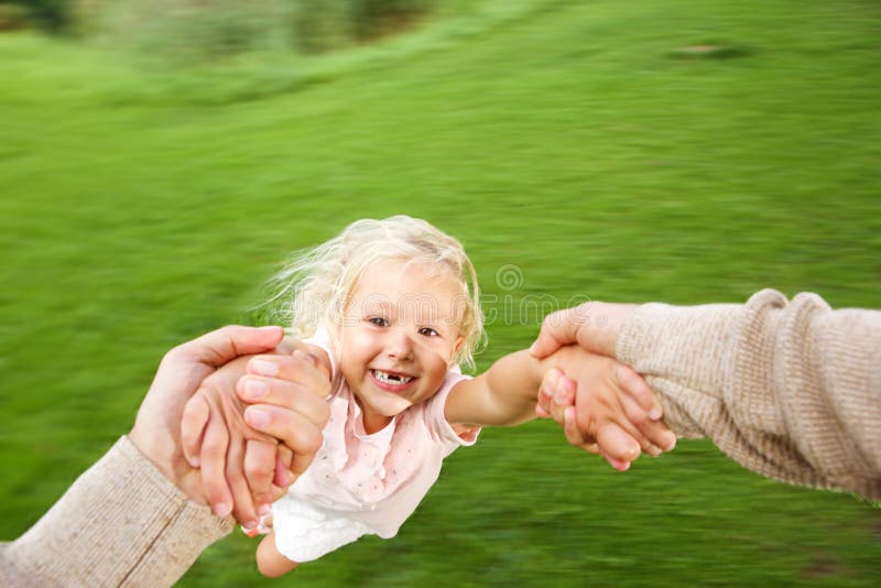 Cute little girl being spun in circles at park