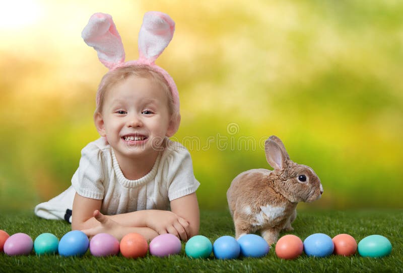 Cute Little Girl with a Bunny Rabbit Has a Easter at Green Grass